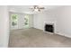 Inviting living room features neutral carpet, a fireplace, two bright windows and a ceiling fan, enhancing comfort at 105 Hiddenwood Ct, Garner, NC 27529