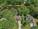 Aerial view of a beautiful home surrounded by mature trees and a serene lake at 105 Highlands Lake Dr, Cary, NC 27518