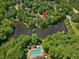 Aerial view of a lakeside home with community pool nestled amongst mature trees at 105 Highlands Lake Dr, Cary, NC 27518