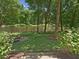 Spacious backyard featuring a fire pit, lush greenery, and serene lake views at 105 Highlands Lake Dr, Cary, NC 27518