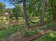 Lush backyard featuring mature trees, lake views and a relaxing hammock at 105 Highlands Lake Dr, Cary, NC 27518