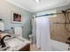 Bright bathroom with a granite countertop, shower and bath combination, and a colorful print hanging on the wall at 105 Highlands Lake Dr, Cary, NC 27518