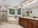 Bright bathroom with a double vanity, glass shower, and luxurious corner bathtub at 105 Highlands Lake Dr, Cary, NC 27518