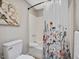 Bathtub shower with floral shower curtain and neutral wall paint at 105 Highlands Lake Dr, Cary, NC 27518