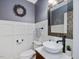 Charming powder room with white wainscoting, vessel sink, and decorative mosaic mirror at 105 Highlands Lake Dr, Cary, NC 27518