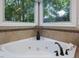 Close-up of a corner bathtub featuring a tile backsplash and bronze fixtures at 105 Highlands Lake Dr, Cary, NC 27518