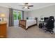 Cozy bedroom features a ceiling fan, neutral decor, a bed with white linens, and an office area at 105 Highlands Lake Dr, Cary, NC 27518