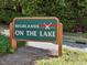 A green Highlands on the Lake sign with two canoes atop a grassy hill at 105 Highlands Lake Dr, Cary, NC 27518