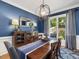 Stylish dining room with blue walls, modern chandelier, and large window view at 105 Highlands Lake Dr, Cary, NC 27518