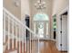 Bright foyer with hardwood floors, staircase, and elegant glass front door at 105 Highlands Lake Dr, Cary, NC 27518