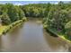 Scenic lake view surrounded by lush greenery offering serene waterside living at 105 Highlands Lake Dr, Cary, NC 27518