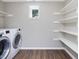 Laundry room with modern washer and dryer and ample storage shelves at 105 Highlands Lake Dr, Cary, NC 27518
