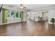 Open-plan living room with an eat-in kitchen, hardwood floors, and a bank of windows overlooking the landscaped backyard at 105 Highlands Lake Dr, Cary, NC 27518