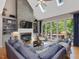 Cozy living room with a stone fireplace, built-in shelving, and large windows with wooded view at 105 Highlands Lake Dr, Cary, NC 27518