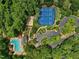Aerial view of the tennis courts and pool nestled in mature trees at 105 Highlands Lake Dr, Cary, NC 27518