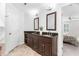 Bathroom featuring a double vanity with dark wood cabinets, granite countertop, tile floors, and updated fixtures at 108 Nimbus Ct, Cary, NC 27513