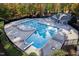 Aerial view of a community pool featuring a diving board, bath house and surrounding trees at 108 Nimbus Ct, Cary, NC 27513