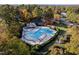 A beautiful community pool surrounded by lush trees with a bath house and parking area at 108 Nimbus Ct, Cary, NC 27513
