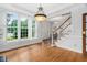 Spacious foyer with hardwood floors, staircase, large windows with shutters, and elegant lighting at 108 Nimbus Ct, Cary, NC 27513