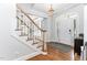 Bright foyer featuring hardwood floors, a staircase with white railings, and a front door with sidelights at 108 Nimbus Ct, Cary, NC 27513