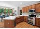Bright kitchen with wooden cabinets, modern appliances, quartz countertops, and an adjacent breakfast nook at 108 Nimbus Ct, Cary, NC 27513