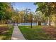 Community tennis courts surrounded by trees and foliage with a pathway and gate at 108 Nimbus Ct, Cary, NC 27513