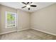Cozy bedroom features neutral walls, carpet, a ceiling fan, and a bright window at 109 Lyngrove St, Holly Springs, NC 27540