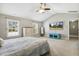 Spacious bedroom with vaulted ceilings, ceiling fan, mounted TV, and light-filled windows at 109 Lyngrove St, Holly Springs, NC 27540