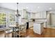 Eat-in kitchen featuring white cabinets, granite countertops, and a cozy dining table at 109 Lyngrove St, Holly Springs, NC 27540