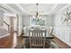 Formal dining room features wainscoting, hardwood floors, and an elegant chandelier at 109 Lyngrove St, Holly Springs, NC 27540