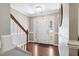 Bright entryway with hardwood floors, white wainscoting and staircase at 109 Lyngrove St, Holly Springs, NC 27540