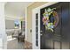 Inviting front door adorned with a colorful wreath, leading to a cozy front porch at 109 Lyngrove St, Holly Springs, NC 27540