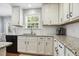 Updated kitchen featuring white cabinets, granite countertops, subway tile backsplash, and stainless steel appliances at 109 Lyngrove St, Holly Springs, NC 27540
