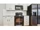 Modern kitchen features white cabinets and black appliances at 109 Lyngrove St, Holly Springs, NC 27540