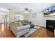 Open-concept living room with hardwood floors, fireplace, and comfortable furnishings at 109 Lyngrove St, Holly Springs, NC 27540