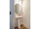 Bright powder room with a pedestal sink, round mirror, and modern fixtures, offering a clean and stylish space at 1101 Compass Dr, Durham, NC 27713