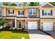 Charming townhomes featuring stone accents, attached garages, and well-maintained front lawns create inviting curb appeal at 1101 Compass Dr, Durham, NC 27713