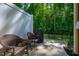 Cozy patio area featuring comfortable wicker seating, a grill, and privacy fence, perfect for outdoor relaxation and entertaining at 1101 Compass Dr, Durham, NC 27713