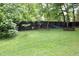 Spacious backyard with lush green grass, privacy fence, and mature trees at 1111 College St, Oxford, NC 27565