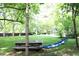 Shady backyard with hammock strung between trees and picnic table at 1111 College St, Oxford, NC 27565