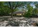 Spacious backyard featuring a screened-in porch, a large concrete patio, and mature trees at 1111 College St, Oxford, NC 27565