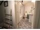 A bathroom with decorative patterned tile flooring, a sink, a toilet, and a bathtub with shower curtain at 1111 College St, Oxford, NC 27565