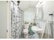 Bright bathroom with black and white patterned floor tiles, shower with curtain, and white pedestal sink at 1111 College St, Oxford, NC 27565