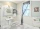 Traditional bathroom with pedestal sink, decorative fixtures, and natural light from the window at 1111 College St, Oxford, NC 27565