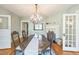 A dining room with a decorative chandelier, fireplace, and beautiful wood floors at 1111 College St, Oxford, NC 27565
