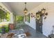 Inviting front porch with black door, decorative wreath and lighting, and painted grey deck boards at 1111 College St, Oxford, NC 27565