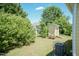Private backyard with lush greenery, storage shed, and a seating area at 116 Laurel Ave, Durham, NC 27701