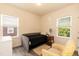 Cozy bedroom with a daybed, chair, and natural light from two windows at 116 Laurel Ave, Durham, NC 27701