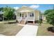 Charming yellow home featuring a cozy front porch with white railings and a well-maintained lawn at 116 Laurel Ave, Durham, NC 27701