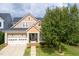 Inviting exterior view of a two-story home featuring a well-manicured lawn, two-car garage, and charming front porch at 121 Bridgegate Dr, Cary, NC 27519
